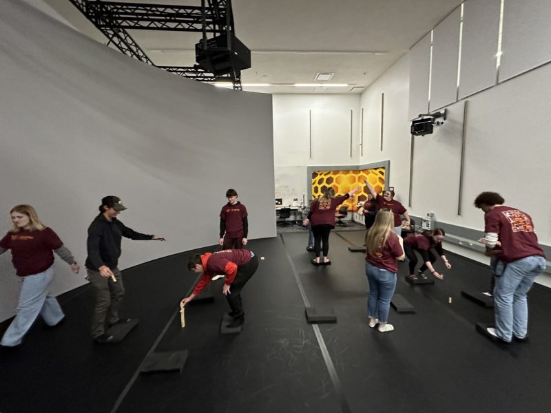 Image of the Sandbox at the Center for the Arts, with students balancing on foam blocks while stacking small wooden blocks.